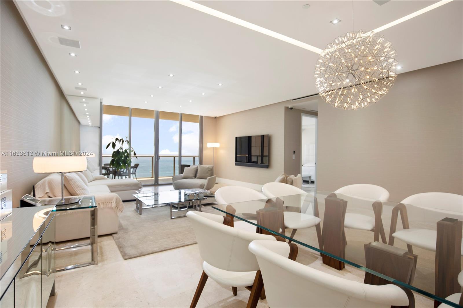 a living room with furniture a chandelier and a flat screen tv