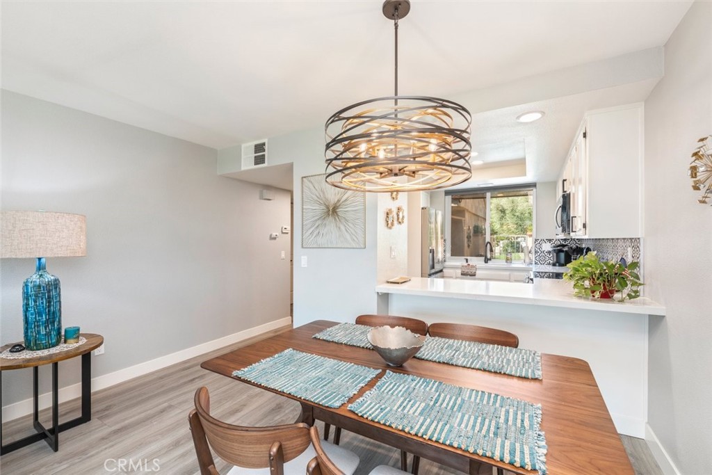 a view of a dining room with furniture a chandelier and wooden floor