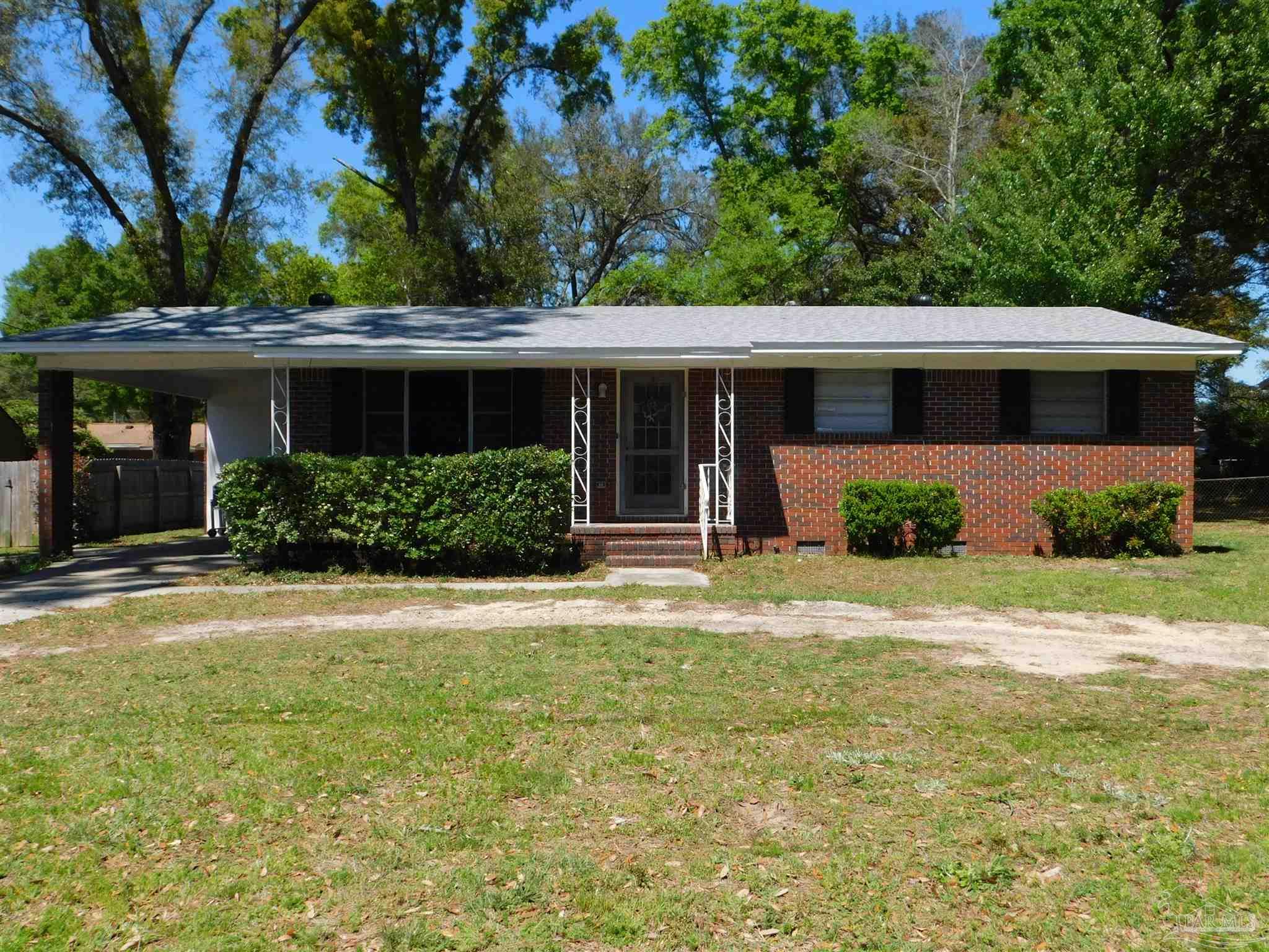 a front view of a house with a yard and potted plants