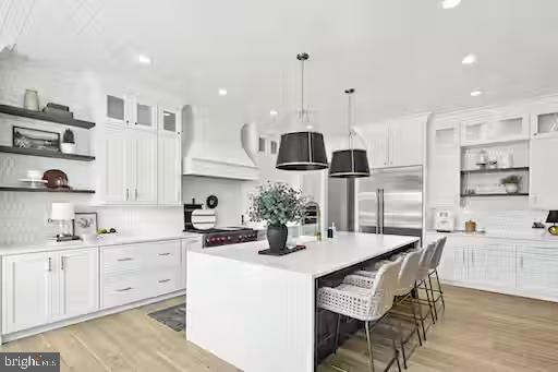 a kitchen with stainless steel appliances kitchen island granite countertop a sink a stove a dining table and chairs