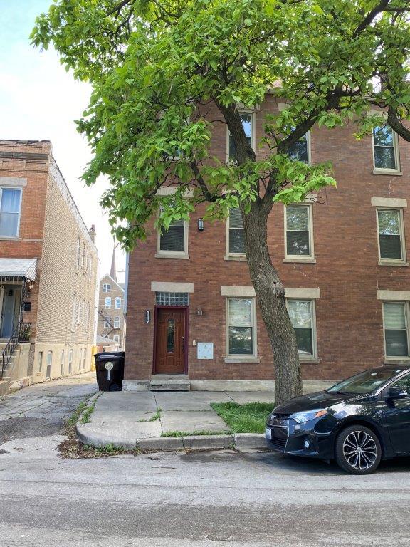 a car parked in front of a brick house