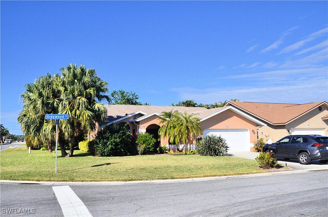 a view of a house with a yard and street