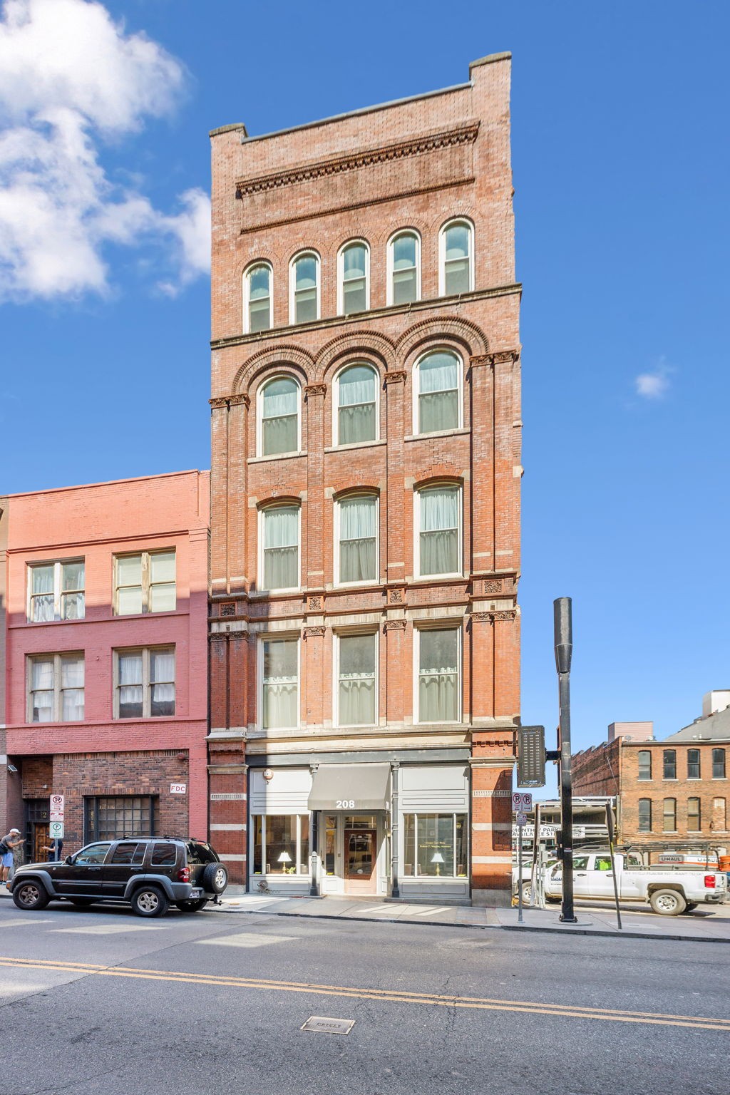 a front view of a building with lot of cars