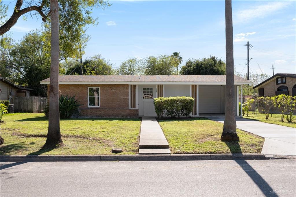 Ranch-style home with a front lawn and a carport