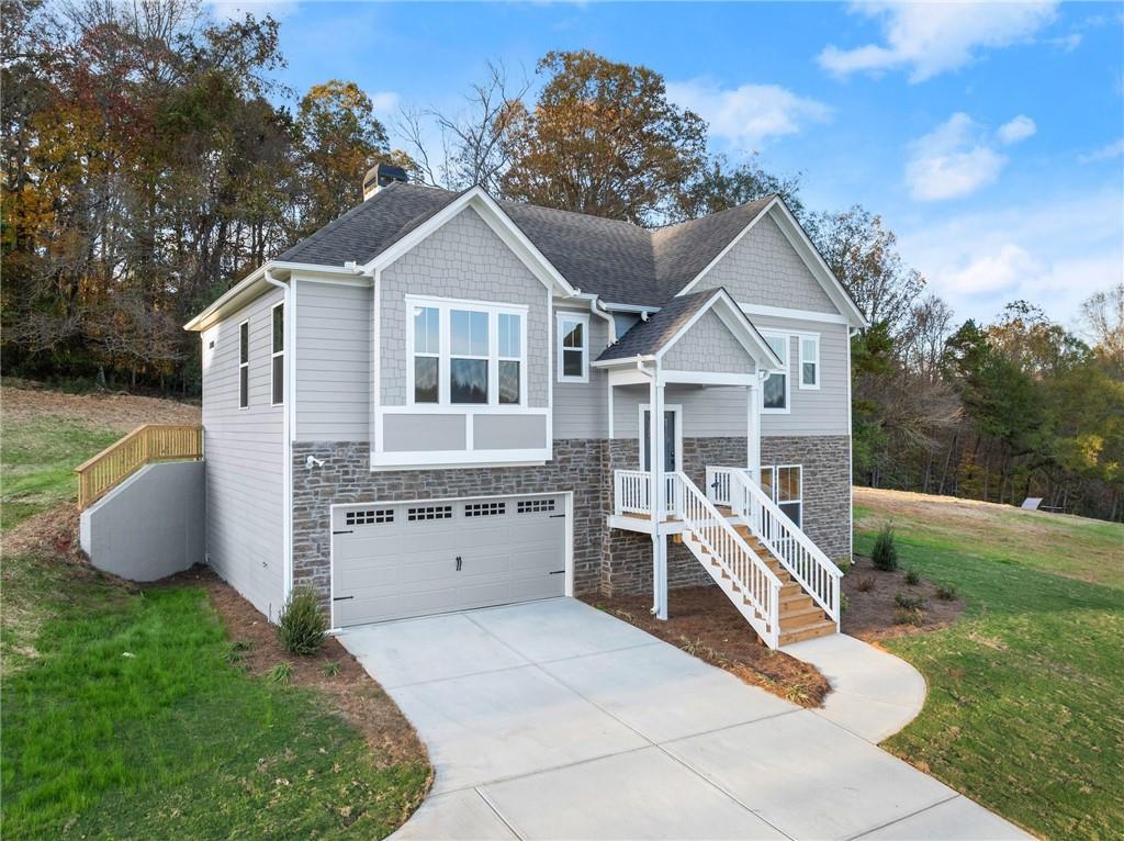 a front view of house with yard and trees in the background