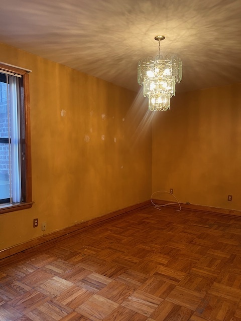 a view of an empty room with a chandelier fan