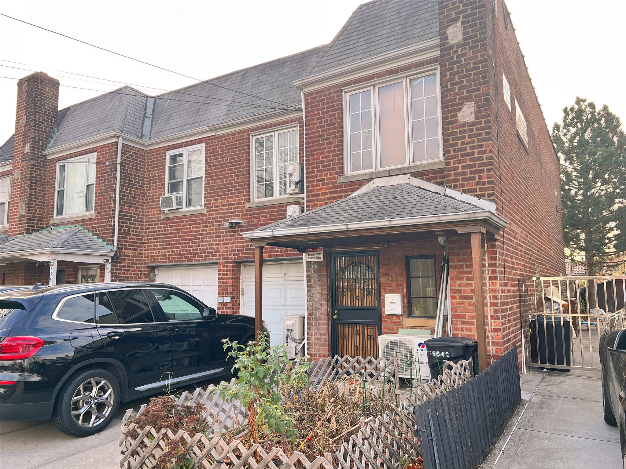 View of front facade featuring ac unit and a garage