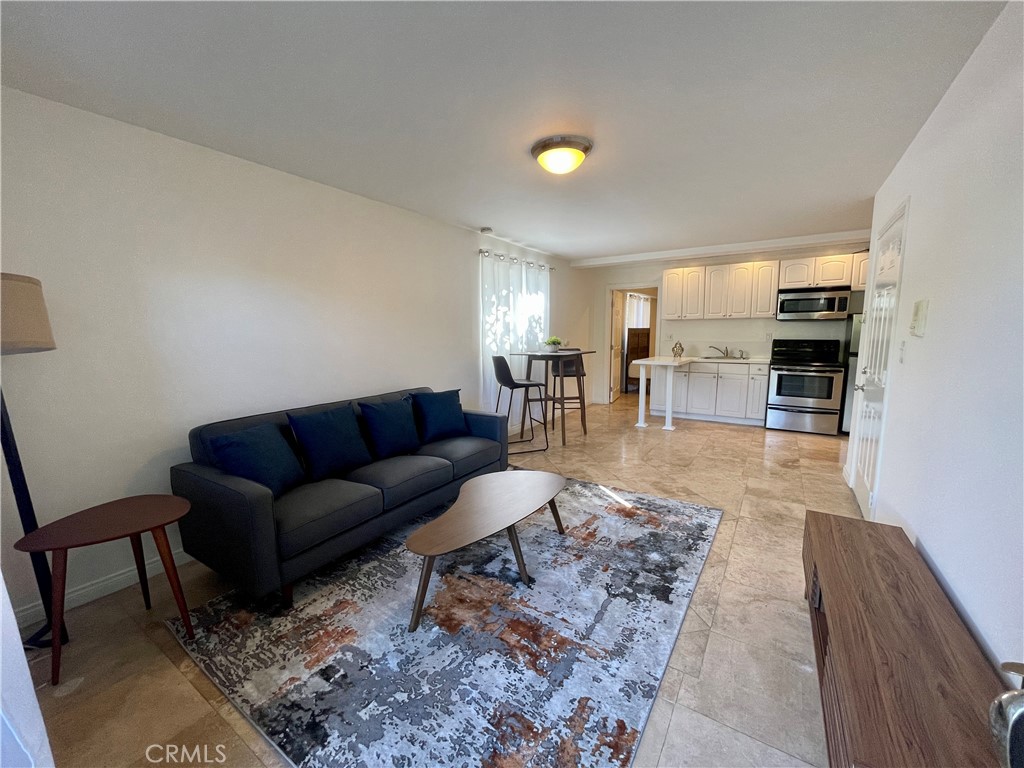 a living room with furniture and a dining table with kitchen view