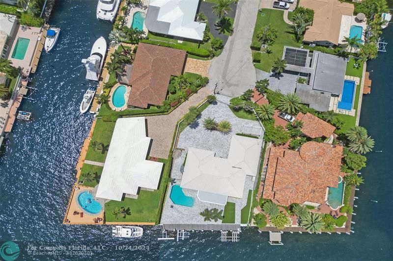 an aerial view of a house with a yard and large trees