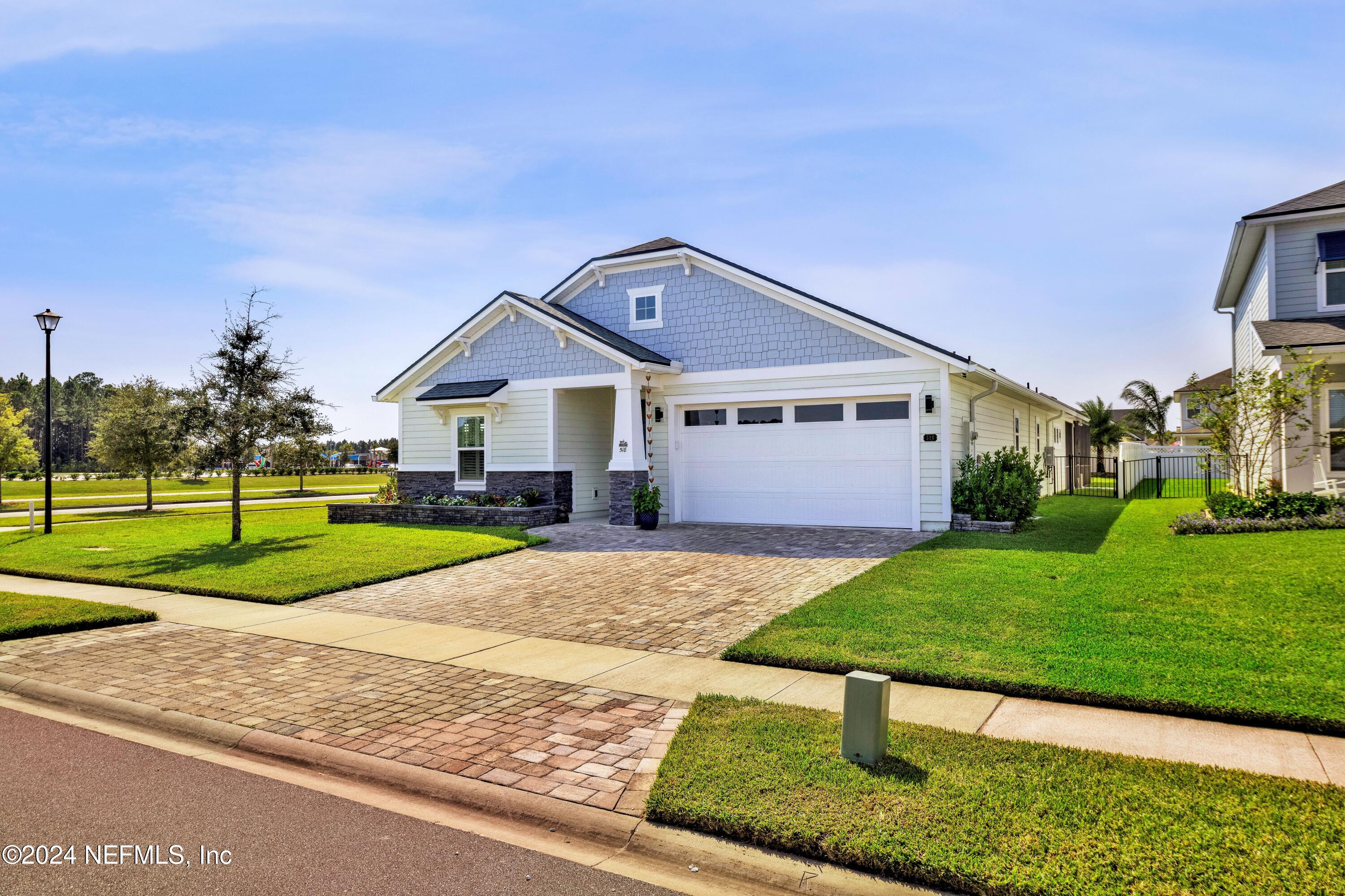 a front view of a house with a yard and road