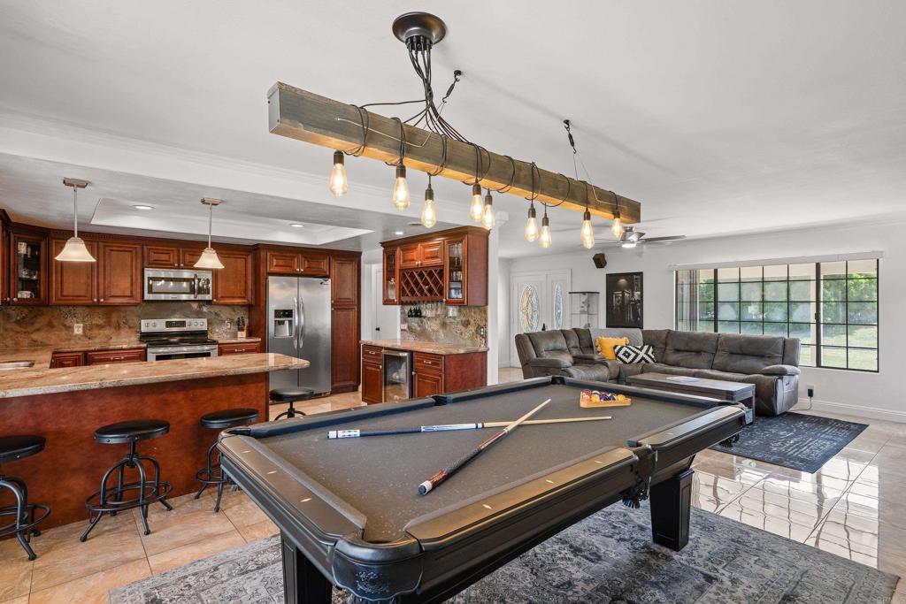 a living room with furniture pool table and a large window