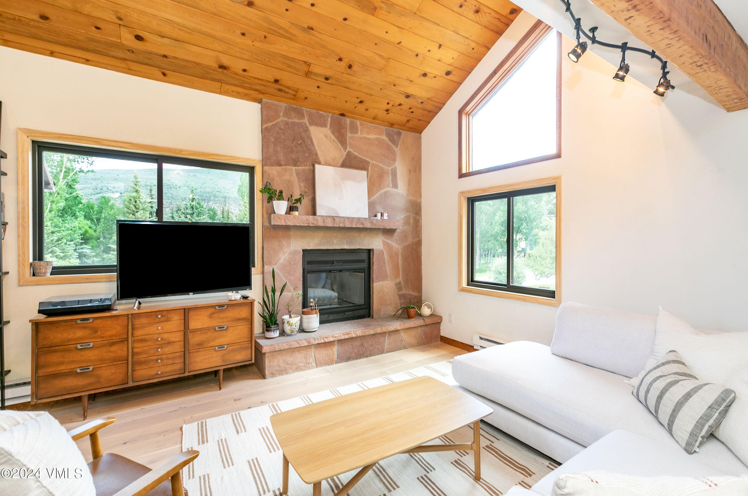 a living room with furniture a flat screen tv and a fireplace