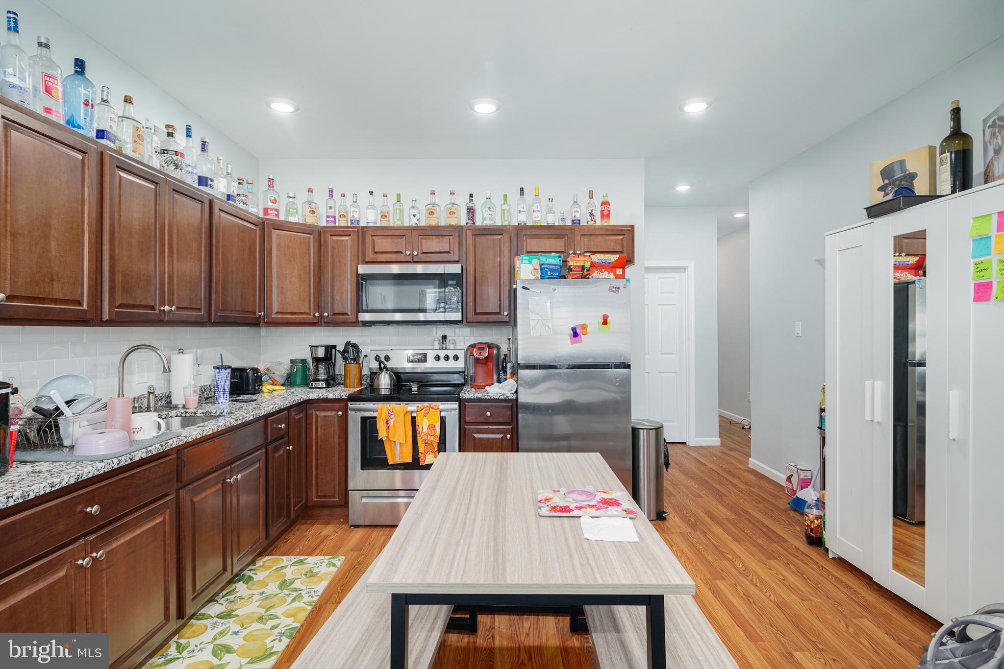 a kitchen with stainless steel appliances granite countertop a refrigerator sink and wooden cabinets