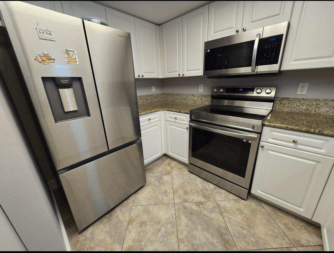 a kitchen with stainless steel appliances a refrigerator a sink a stove a microwave and cabinets