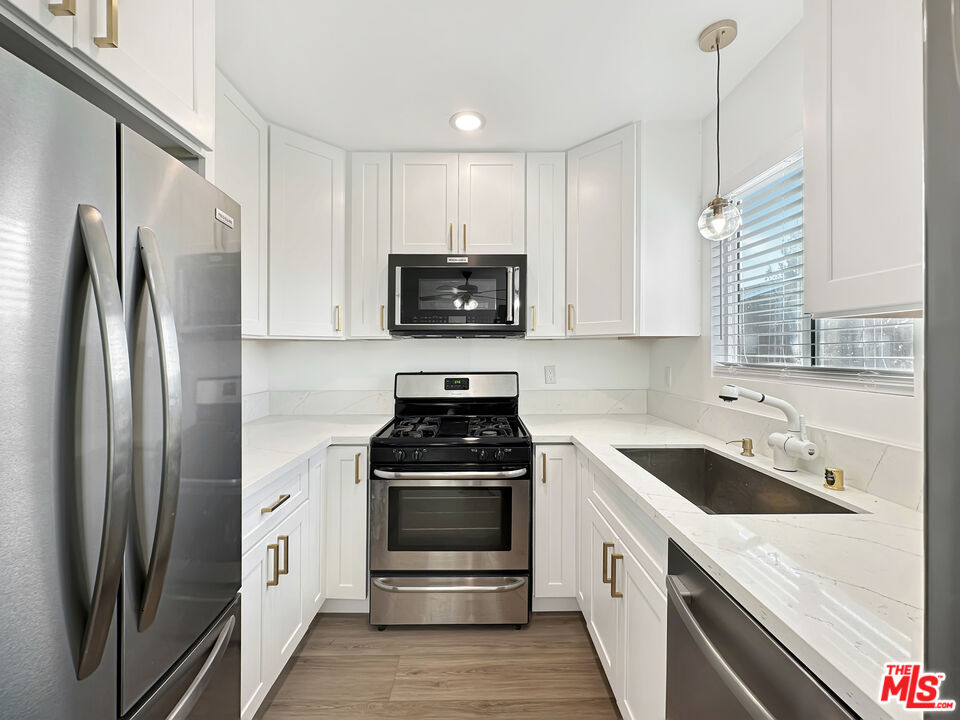 a kitchen with a sink stove and refrigerator