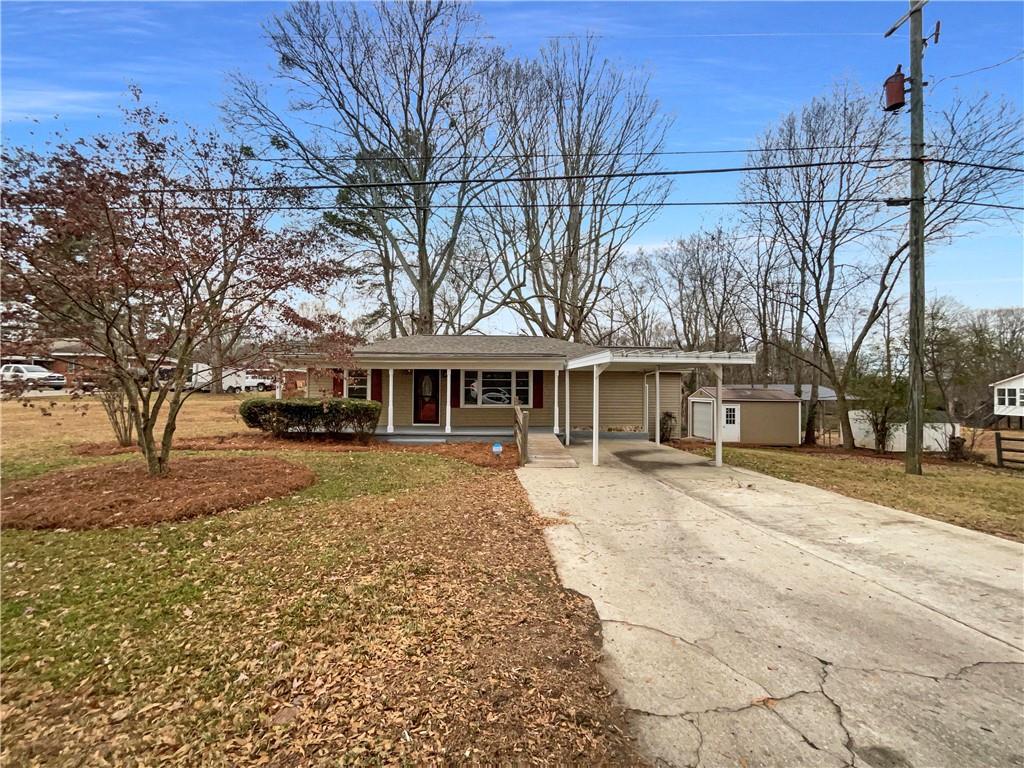 a front view of a house with a yard and large trees