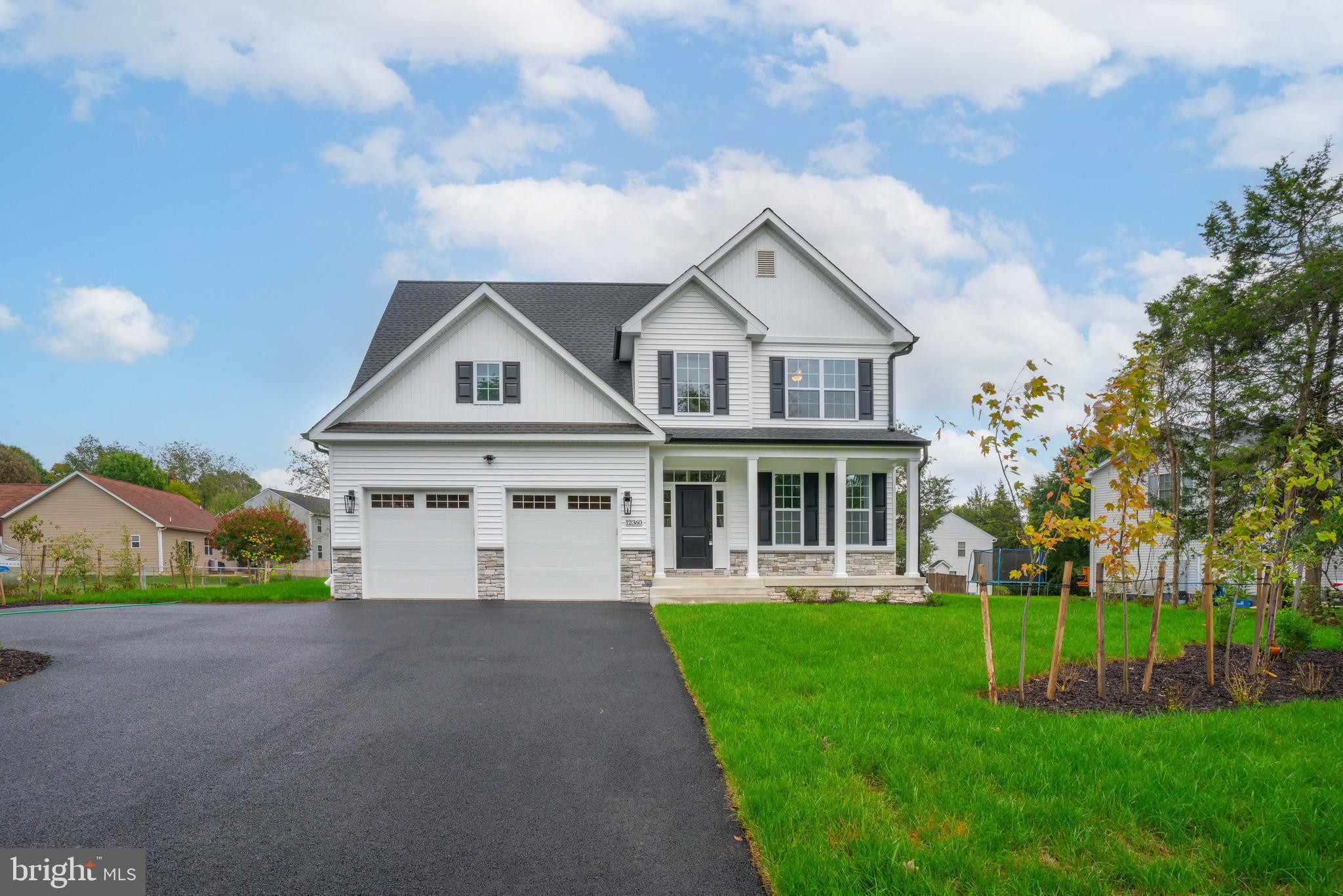 a front view of a house with a yard and trees