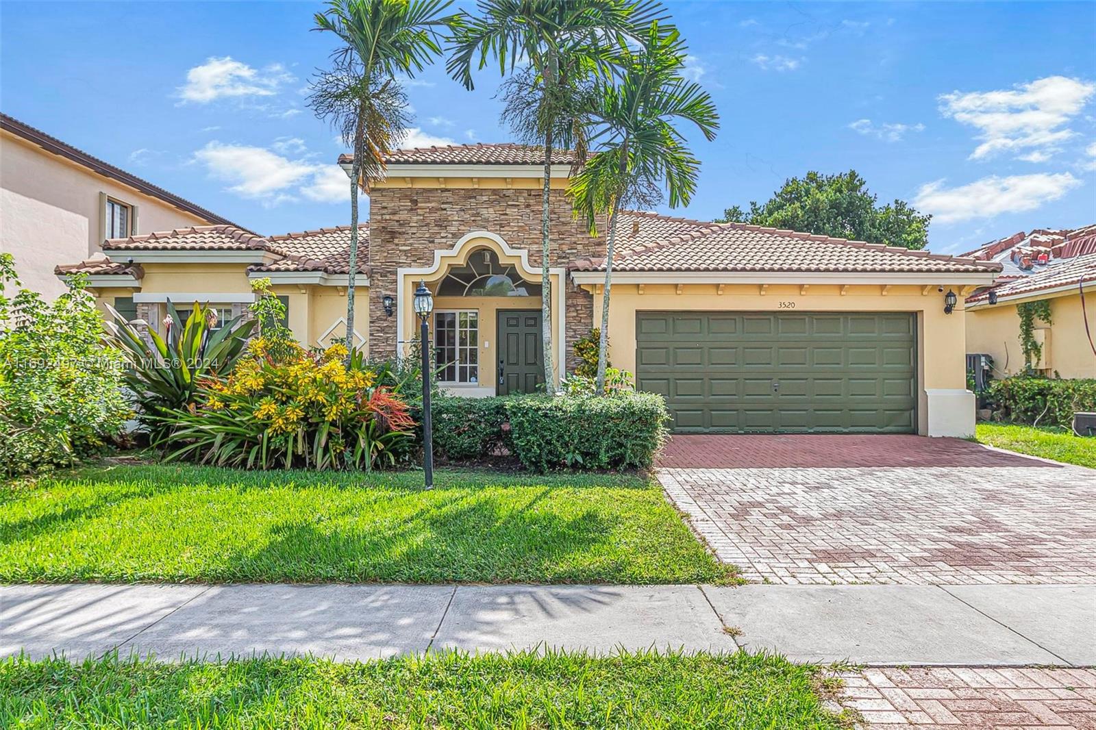 a front view of a house with a yard and potted plants