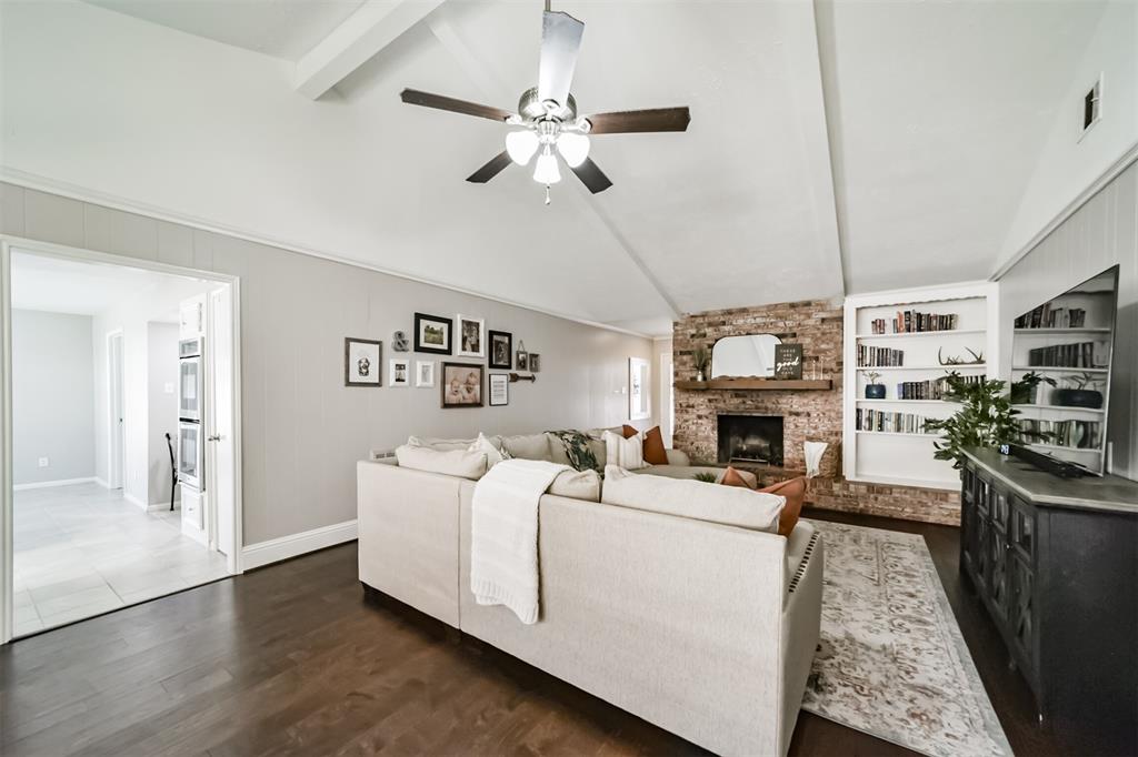 Enjoy this beautiful living space with the large brick wood burning fireplace with gas connection as it seamlessly adds charm with the extra-large hearth and built-in bookcase.