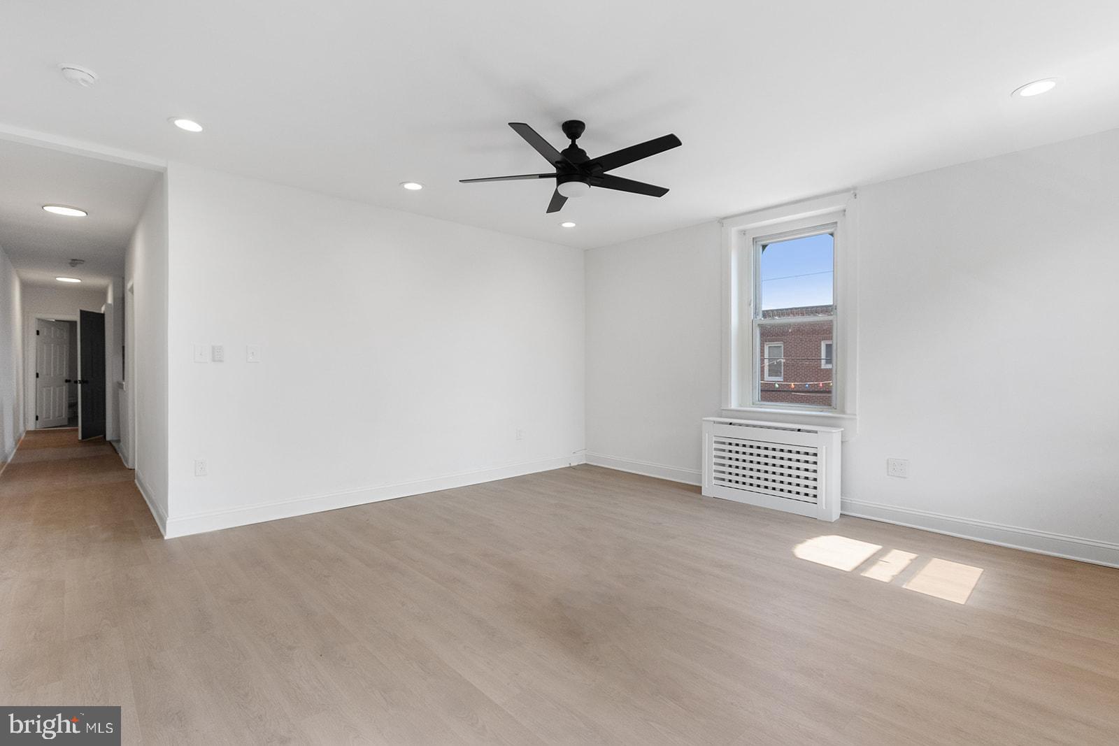 an empty room with windows and fan