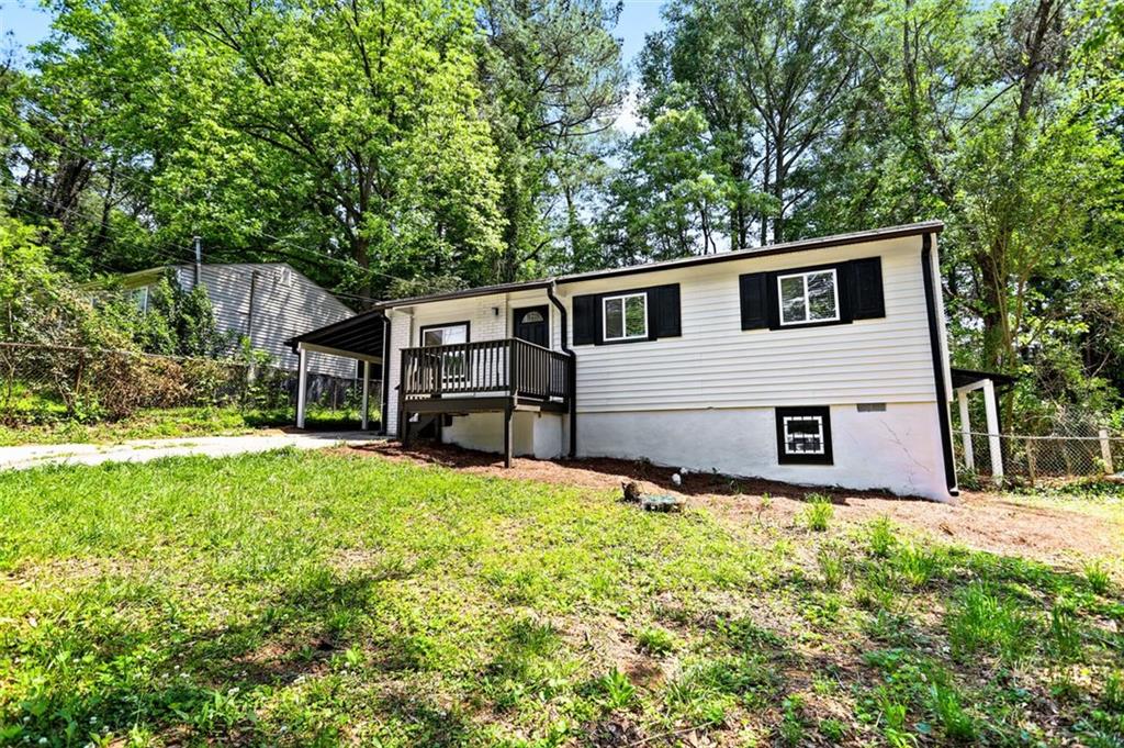 a front view of house with yard and trees in the background