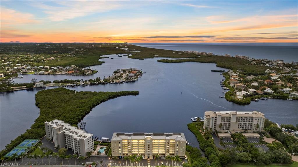 an aerial view of ocean and residential houses with outdoor space