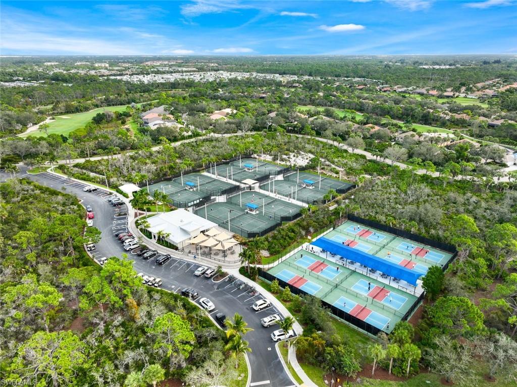 an aerial view of residential houses with outdoor space and trees