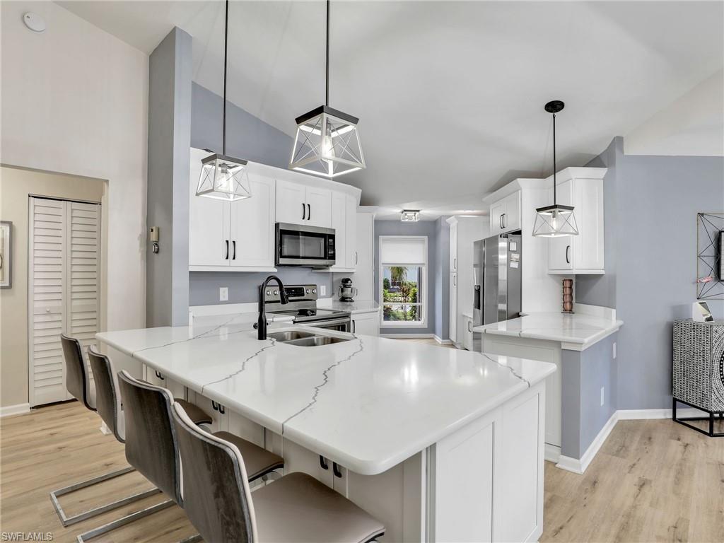 a kitchen with stainless steel appliances a table chairs and white cabinets