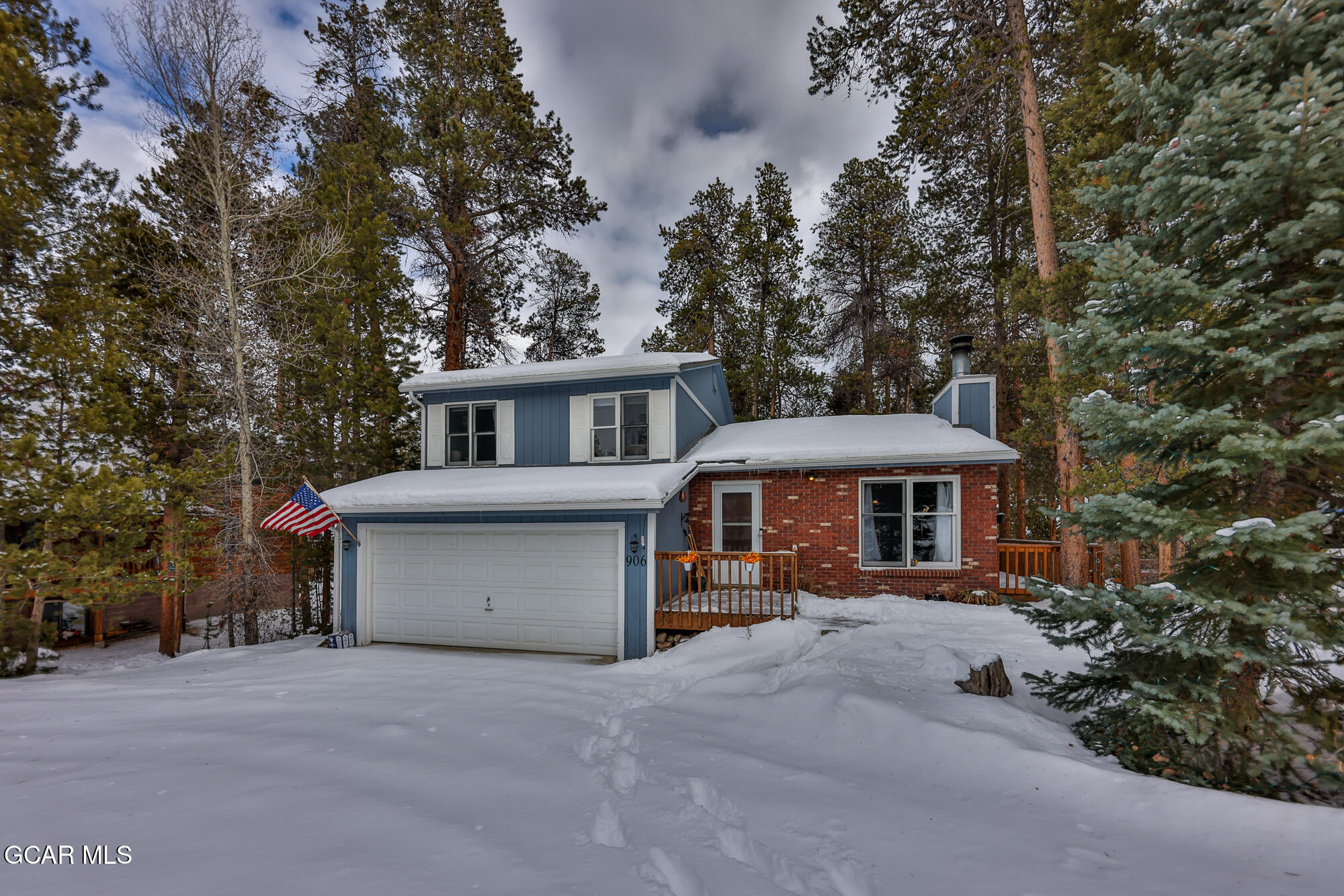 a view of a house with a yard and large trees