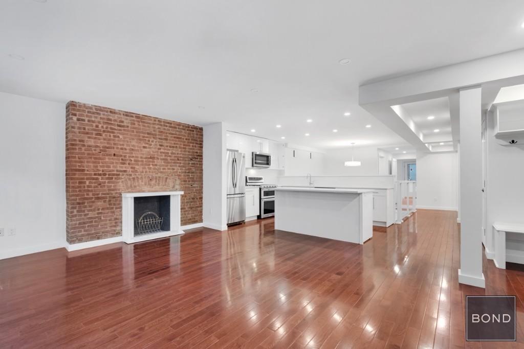 a view of empty room with wooden floor and fireplace