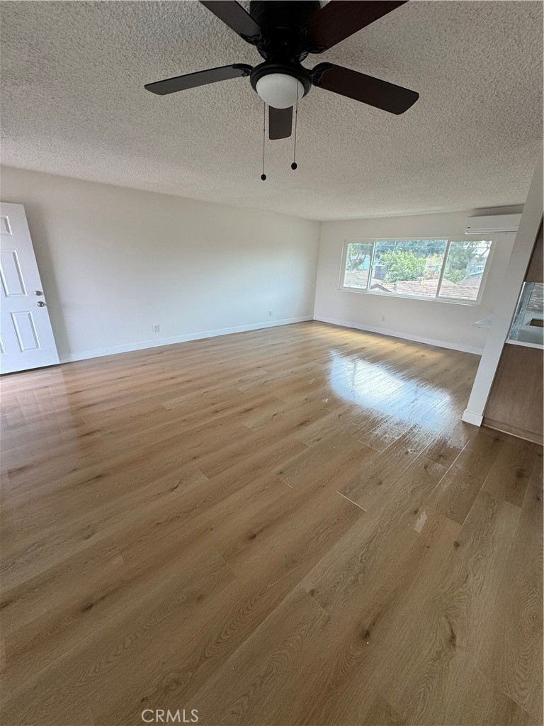 en empty room with wooden floor and windows