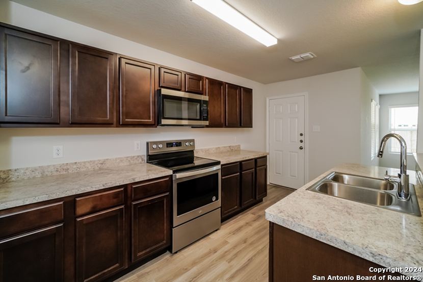 a kitchen with granite countertop a sink and steel appliances