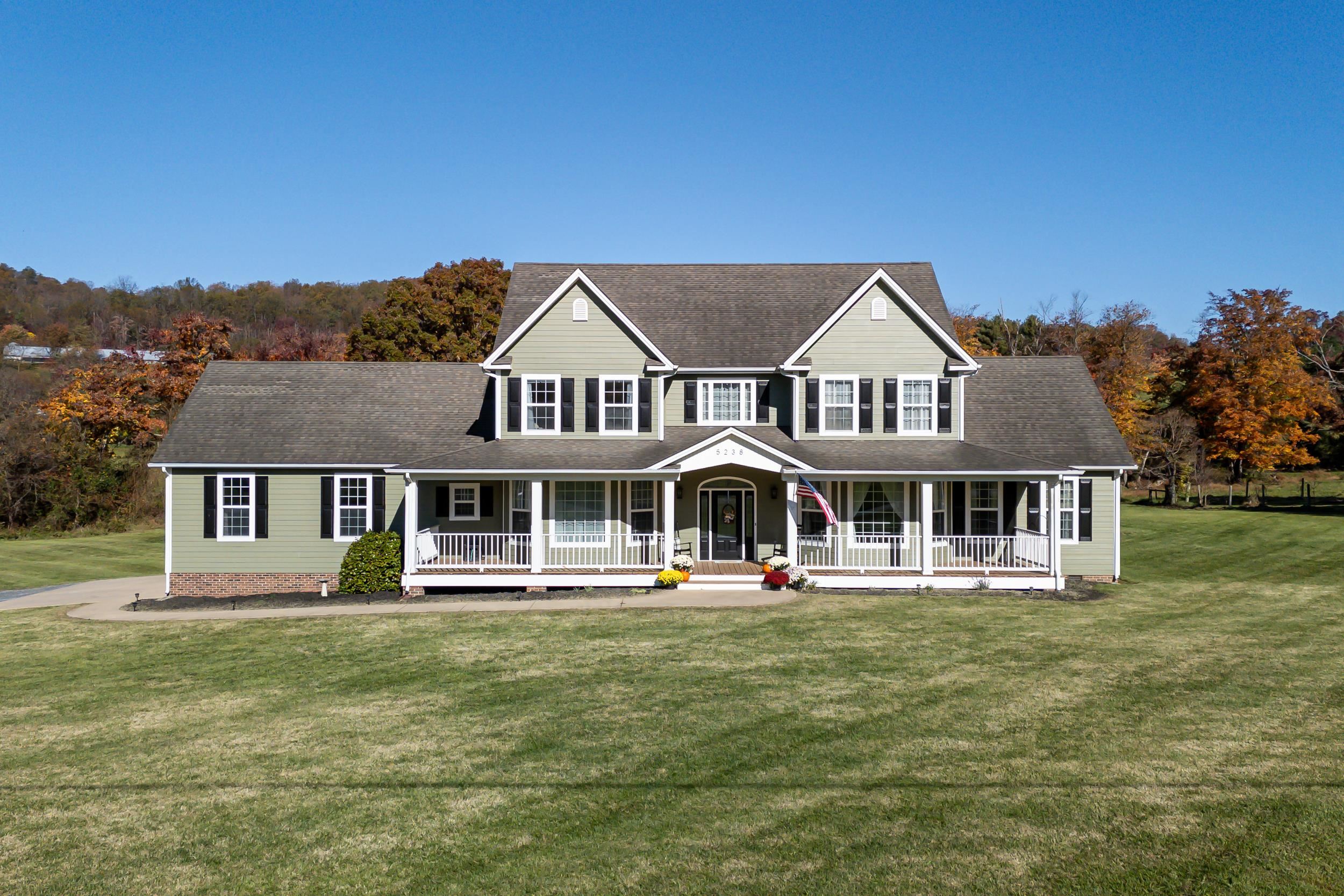 a front view of a residential houses with yard and green space