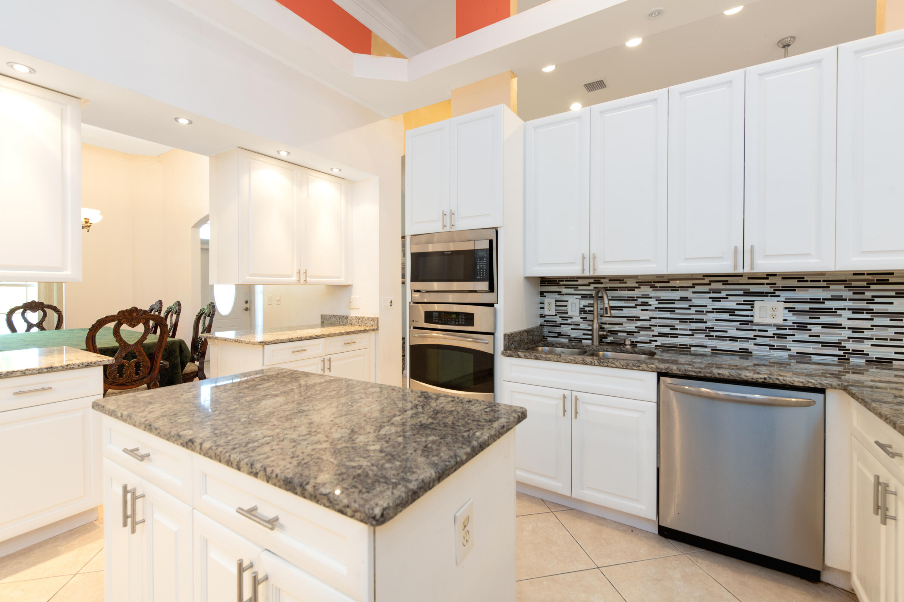 a kitchen with kitchen island granite countertop a sink counter top space appliances and cabinets