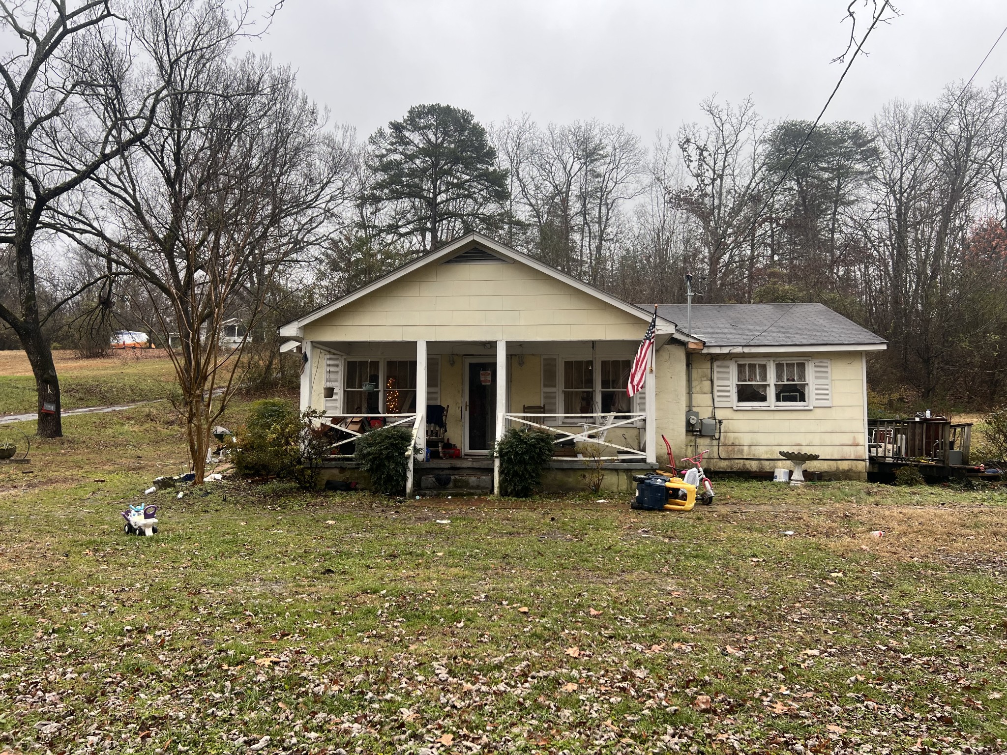 a front view of a house with a garden and trees