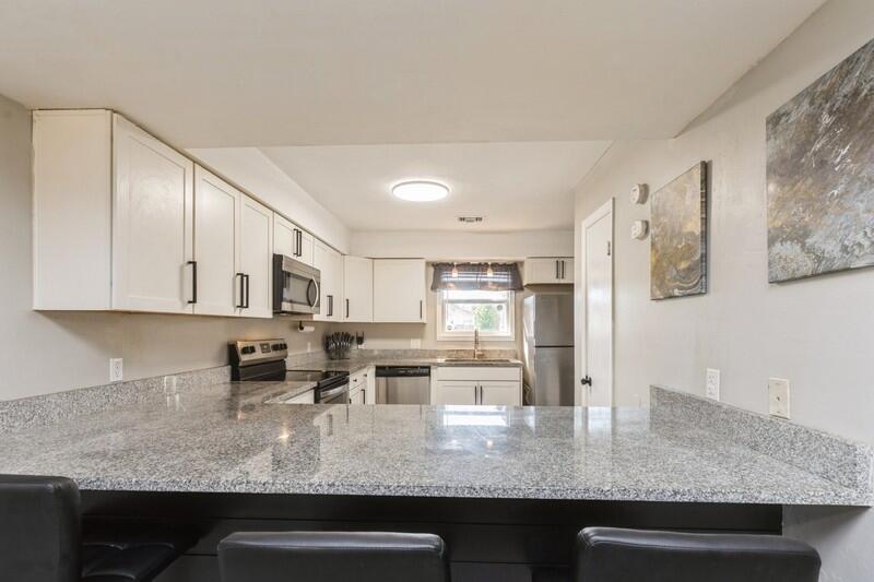 a kitchen with stainless steel appliances granite countertop a sink stove and cabinets