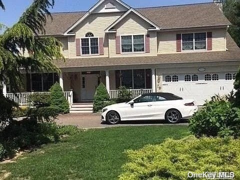 a view of a house with a garden and parking space