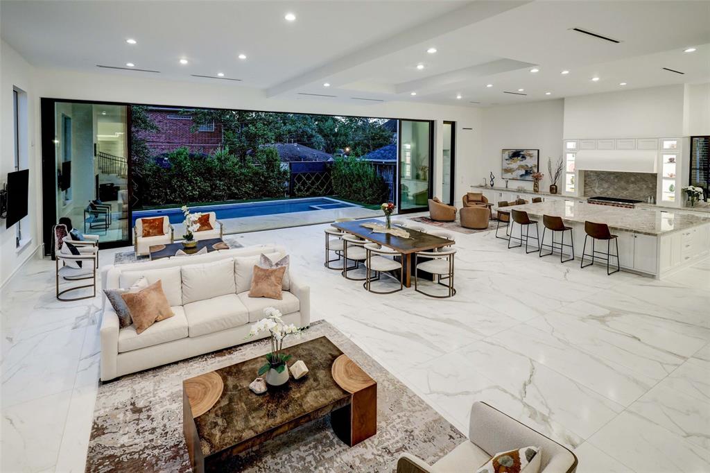 This stunning living room offers a perfect blend of comfort and elegance, with plush seating arrangements and floor-to-ceiling glass panels providing captivating views of the pool. It's an idyllic space for relaxation and entertaining.