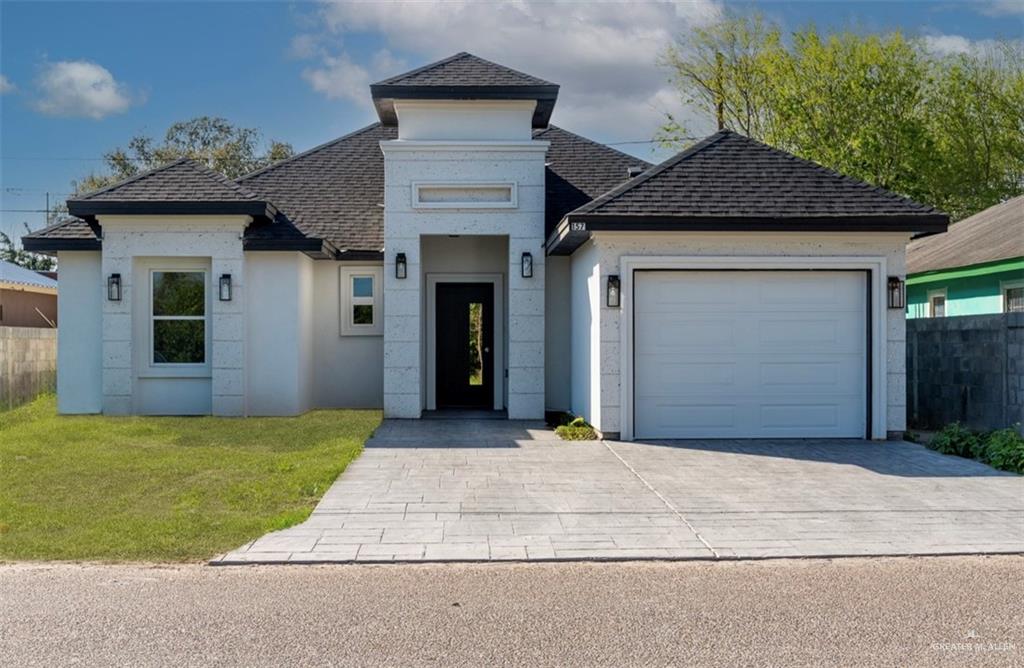 a front view of a house with a yard and garage