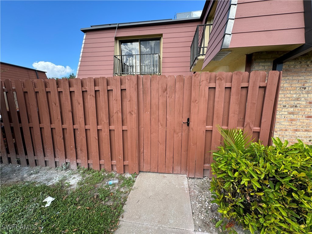 a backyard of a house with potted plants and wooden fence