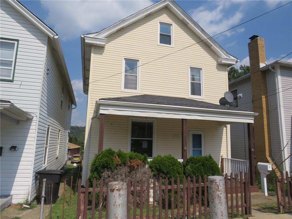 a front view of a house with plants