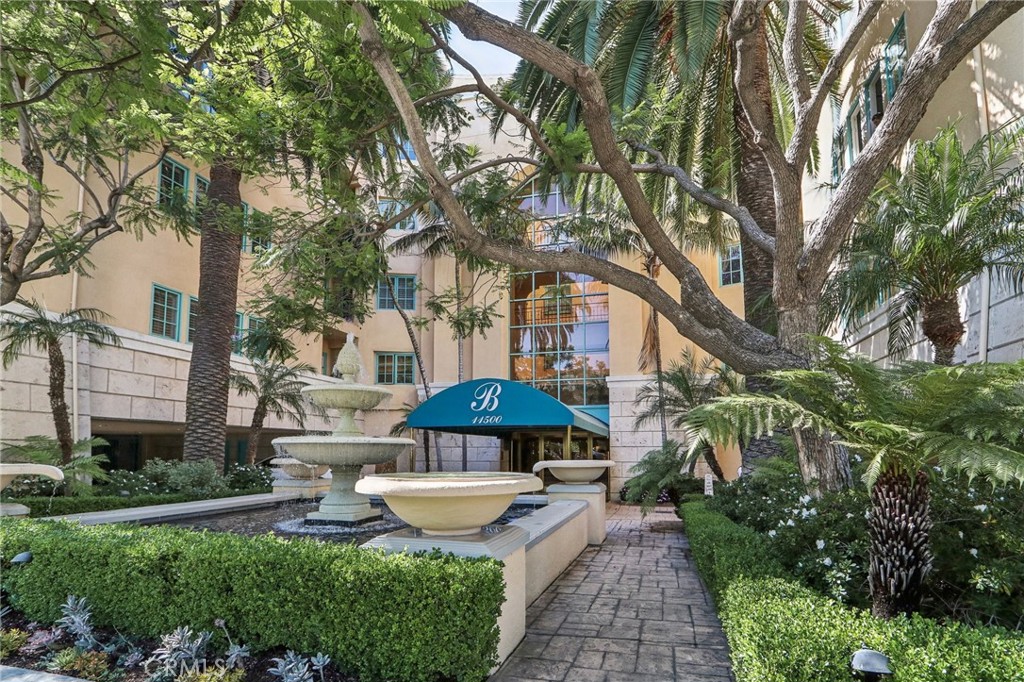 a view of a backyard with potted plants and a fountain