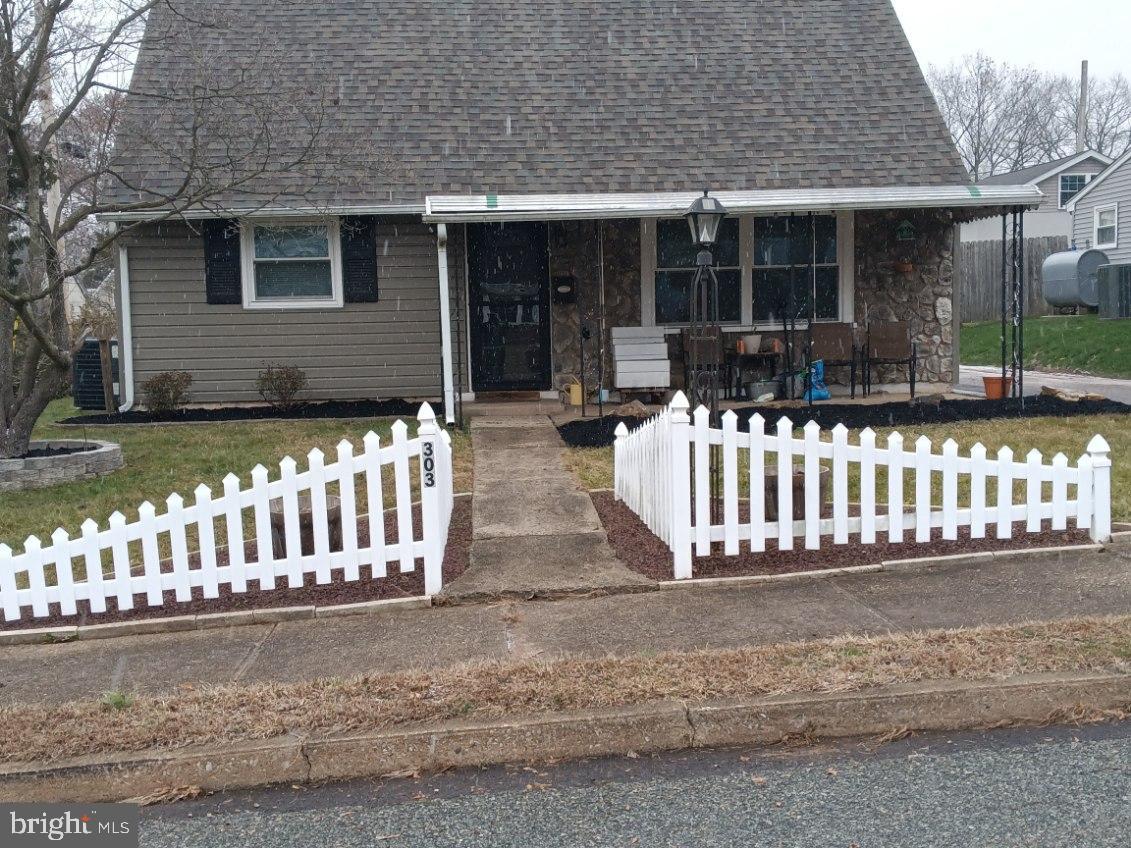 a view of a house with a small yard and wooden fence