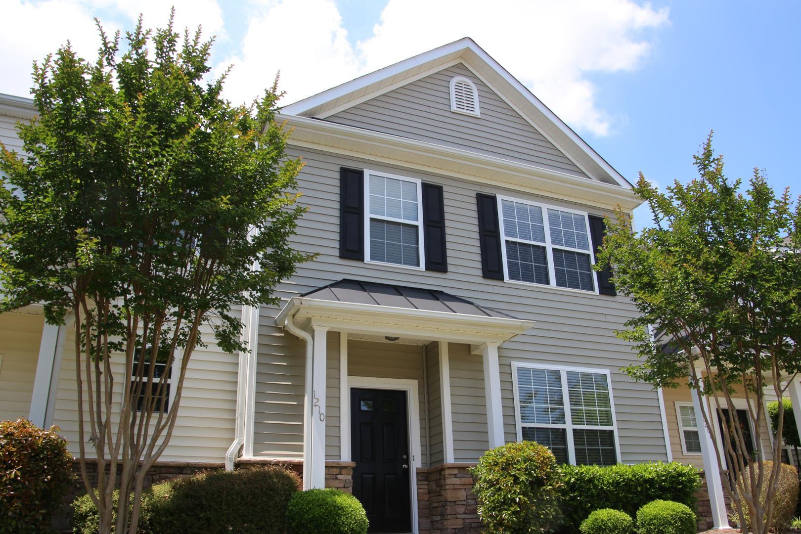 a front view of a house with a tree