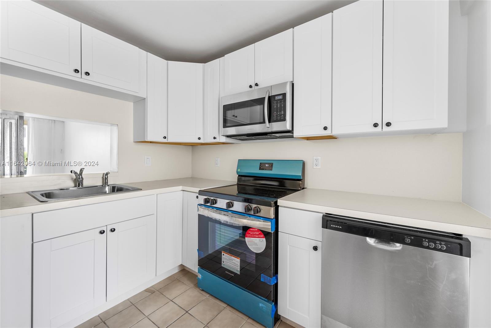 a kitchen with stainless steel appliances white cabinets and a sink