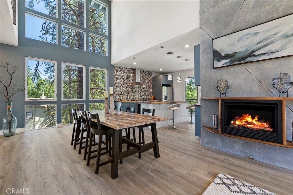 a dining room with furniture a fireplace and wooden floor