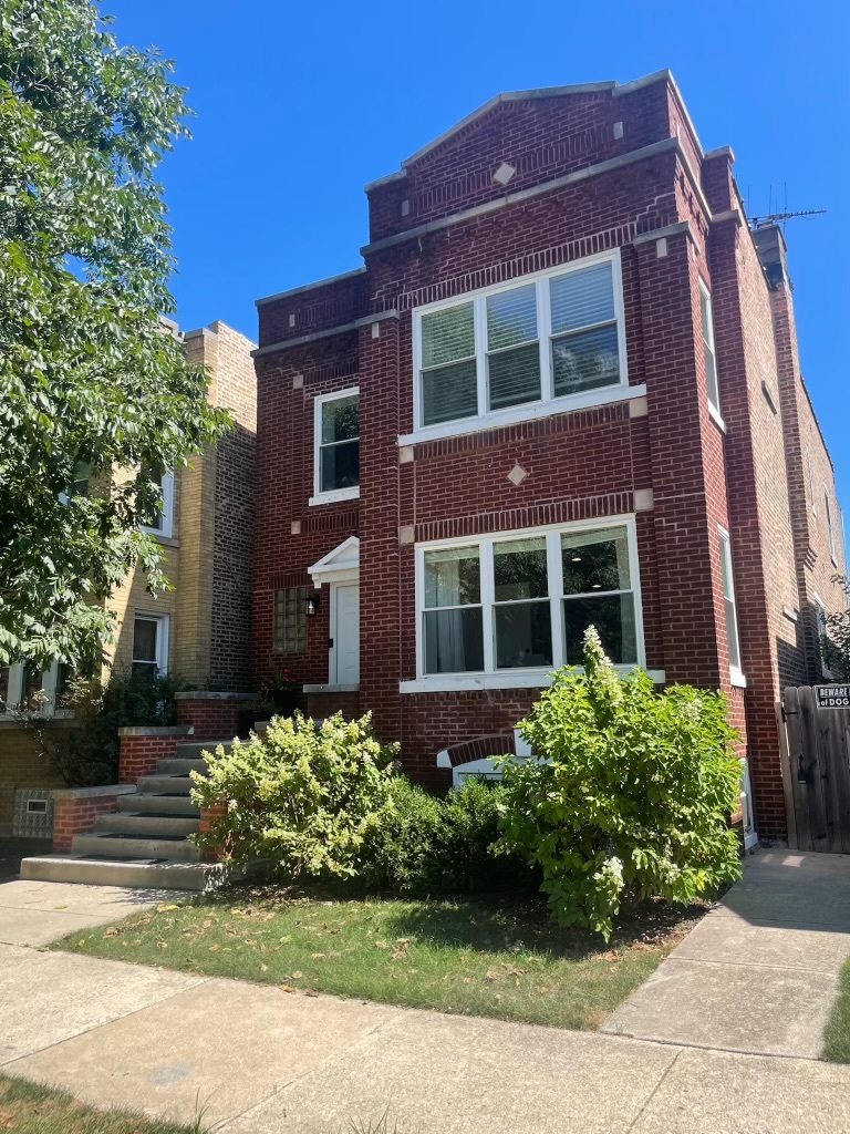 a view of a brick building next to a yard