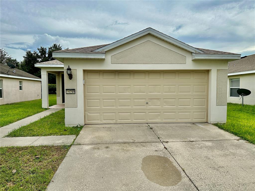 a front view of a house with a yard and garage