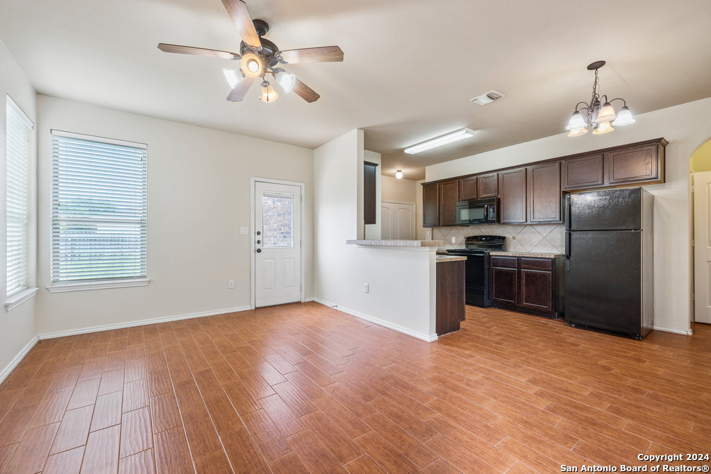 a kitchen with granite countertop a refrigerator oven a sink and dishwasher