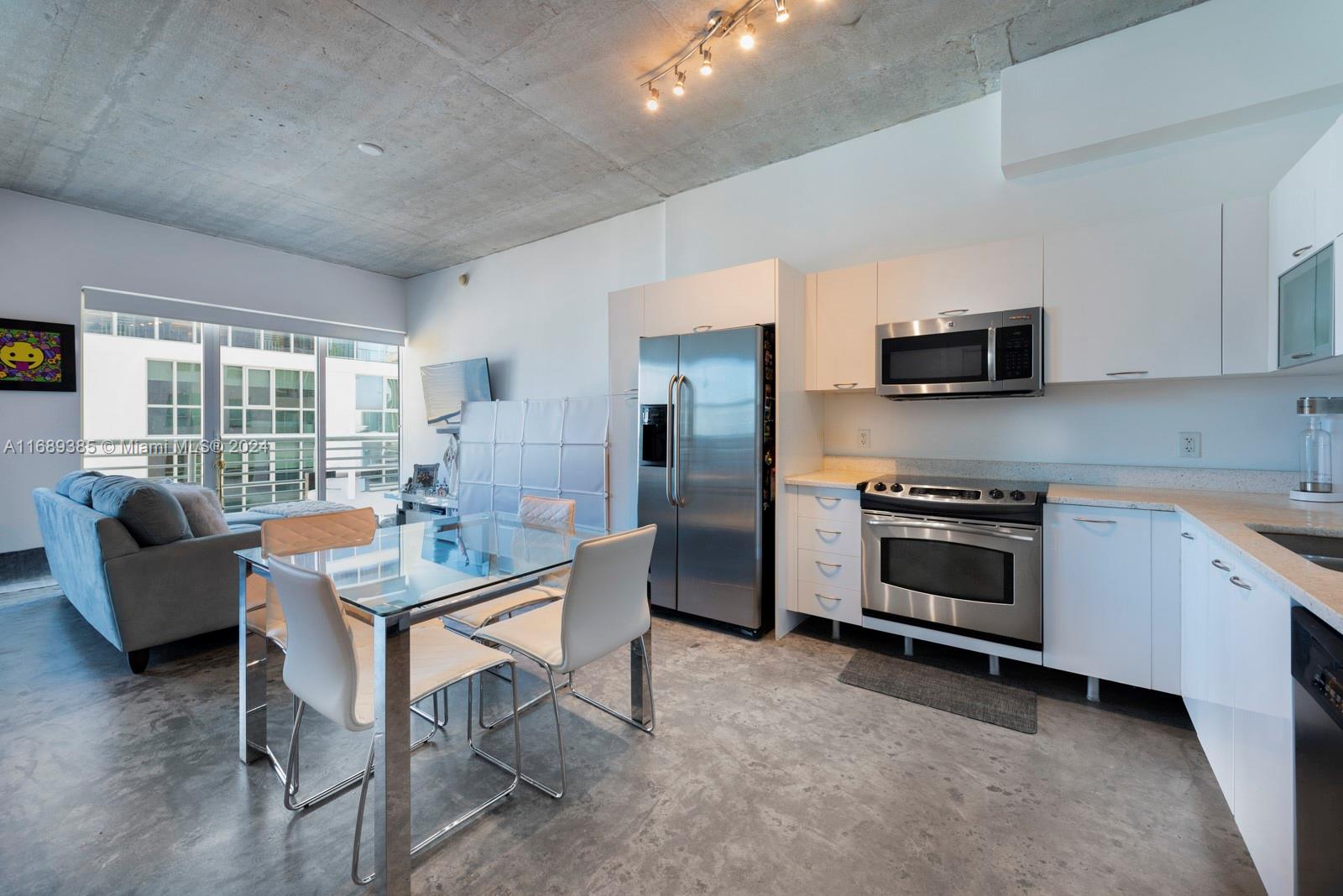 a kitchen with a table chairs microwave and cabinets